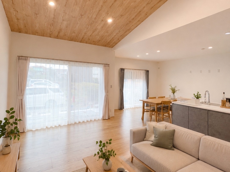 勾配天井が広がる開放的なリビングが魅力の平屋のお住まい。天井の一部に木目クロスを採用することで、空間に温かみとやさしい表情をプラスしました。シンプルな中にも素材感が際立つ、心地よいナチュラルな住まいです。